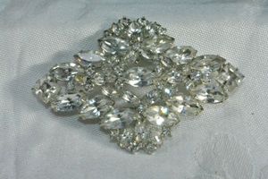 lot 202 image: Signed Weiss prong set foil back rhinestone large silver finish broochpin. 3W x 2H. marked Weiss on reverse.
