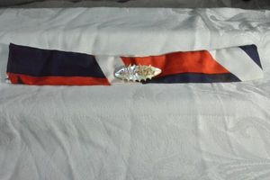 lot 208 image: Antique Mother of Pearl and gold finish wire script Mother broochpin on red white blue 9.5L fabric ribbon. 1.5W