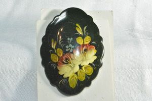 lot 209 image: Traditional Russian folk art hand painted black lacquerware brooch  pin with floral imagery on charity donation Thank You card. Has Russian words on reverse. 2.5H x 1.5W