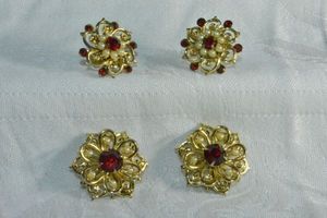lot 210 image: Victorian revival style MCM jewelry in gold finish. Includes (2) red rhinestone and faux seed pearl pins with pendant loops and matching screw back earrings. One pin missing 1 seed pearl. Pins 1W
