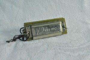 lot 211 image: Piano brand mini harmonica. Marked Made in occupied Japan (1945-1952). 1.5L