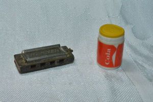 lot 297 image: Advertising items. Includes Hohner Little Lady mini harmonica and figural Coca Cola can with removable top.