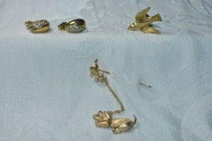 lot 305 image: Signed Avon jewelry. Includes dog and cat pin, peace dove pin and pave poststud earrings
