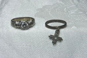 lot 336 image: (2) Sterling Silver rings. Cross charm ring size 5.25, bezel set solitaire ring Size 7. Both marked 925