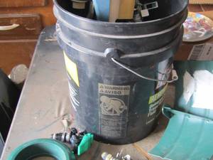lot 65 image: 5 gallon bucket of various water sprinklers - water hose holder