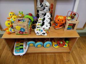 lot 188 image: Contents of Cabinet.  Battery Powered Toys, Puzzles, Sensory Toys & More.  Cabinet Not Included.