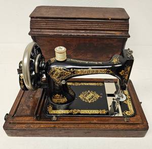 lot 45 image: VINTAGE SINGER HAND CRANK SEWING MACHINE WITH WOODEN CASE AS SHOWN. CHECK IT OUT