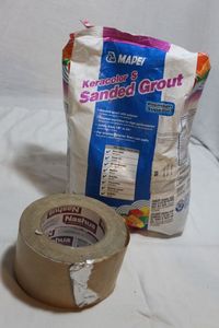 lot 131 image: Unopened Bag of Tile Grout and Roll of Aluminium HVAC Tape