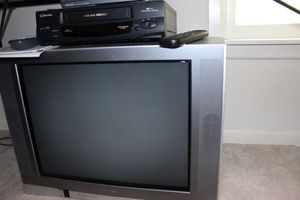 lot 110 image: 27 inch tube television, VCR player and DVD player