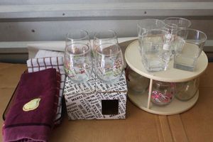 lot 327 image: Wine Tumblers, dish towels, Pyrex Cranberry baking dish, and clear glassware