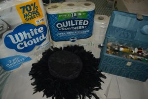 lot 97 image: Black feather Hat, Sewing Kit basket, and Toilet Paper packages unopened