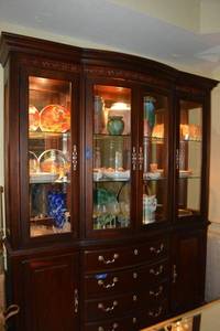 lot 122 image: Cherrywood China hutch with mirrored back, glass shelves and illuminated display case on top with 4 storage drawers and two side cabinets on the bottom. Hutch comes apart in 2 sections. Please bring tools to separate.(not contents) Day 2 pickup only