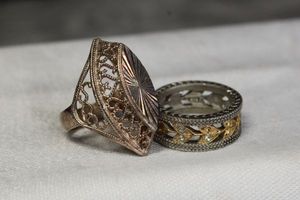lot 11 image: (2) Sterling Silver rings. Band ring size 8 (missing crystals, marked 925) and filigree dome ring size 6.5. (Marked 925 Turkey)