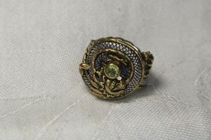lot 34 image: Sterling Silver figural dragon form Echo The Dreamer (Margaret Thurman, QVC) ring with bronze accents and imitation Peridot gemstone. Marked 925 Dream Bronze. Size 6.5