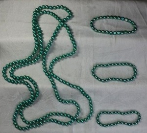 lot 43 image: Green glass faux pearl continuous necklace. Individually knotted 58L with (3) matching glass flat bead stretch bracelets.