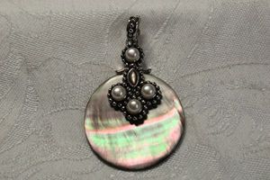 lot 48 image: Sterling Silver Mother of Pearl disc pendant with cultured pearl accents. Marked 925. 2.25L with safety clap bale.