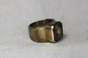 lot 66 image: Brass finish ring with faceted bevel set Smokey Quartz. Size 7.