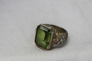 lot 71 image: Faceted bezel set green Topaz ring in brass finish. Size 6.5. Tests as Topaz