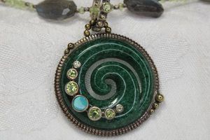 lot 82 image: Sterling Silver Opal station necklace with Spinach Jade disc spiral pendant accented with Opal and Peridot gems. Marked 925 on lobster clasp. 18L. Overall 21L