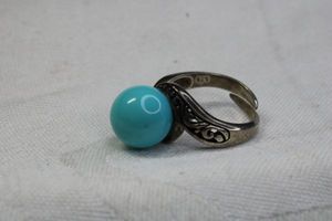 lot 120 image: Sterling Silver bypass ring with blue ceramic or glass topper. Marked 925. Size 7