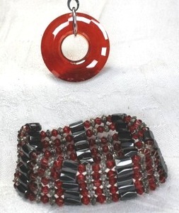 lot 151 image: Sterling Silver 18L oval link necklace with faceted prism red glass disc pendant. Marked 925. Includes a red and black Hematite wrap around bracelet.
