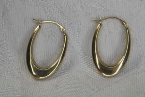 lot 247 image: 14K yellow gold elongated polished oval hoop earrings. Marked 14K and Israel. 1L