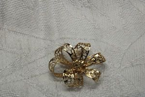 lot 253 image: Pinback or enhancer in flower form. Consignor indicates gold. No markings. Please preview.