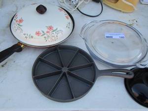 lot 180 image: cast iron corn bread pan, covered Pyrex dish, 2 lids and a red pan