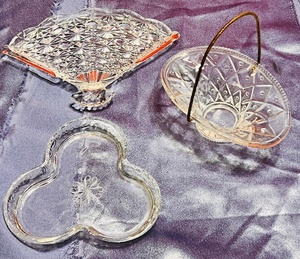 lot 156 image: Three (3) Avon Collectibles - Including Clear Glass Clover Shaped JewelryPerfume Tray, Glass Fan Trinket Dish, & Miniature Glass Basket WGoldtone Handle
