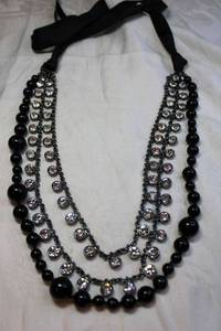 lot 55 image: Graduated black glass bead and silver finish faceted crystal station 3-strand necklace with satin fabric ties. Necklace itself is 18L, Strands about 36