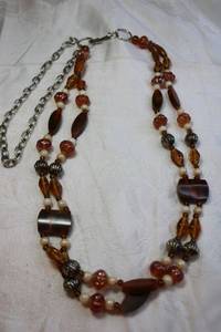 lot 60 image: Mixed material amber glass, wood and brass beads with metal vintage necklace and fish hook clasp. 36L