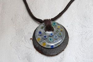 lot 70 image: Vintage leather pendant and corded necklace with Millefiori glass disc. Wood bead clasp. 18L Pendant about 1W