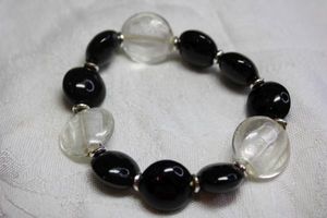 lot 75 image: Black round and clear crackle glass oval bead stretch bracelet.