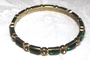 lot 91 image: Faceted emerald green and champagne color glass gold finish bangle bracelet.