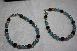 lot 99 image: (2) Artisan crafted matching faceted blue glass, flower and heart bead bracelets. Lobster clasp. 7.5L