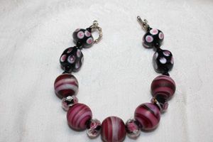 lot 101 image: Satin glass polka dot bead and matte purple striped glass bead bracelet with toggle clasp. 8L