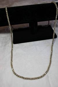lot 105 image: Classic faceted ivory or cream iridescent glass continuous stretch necklace with gold finish spacers. 34L