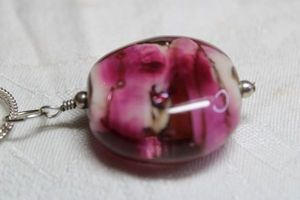 lot 154 image: Pink banded fused glass pendant on silver finish 18L necklace with lobster clasp. Pendant 1.5L
