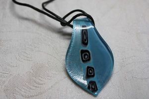 lot 158 image: Dichroic glass pendant with incorporated bale on a 28L leather cord. Pendant 2.25L