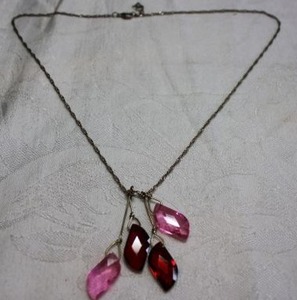 lot 117 image: Twisted link chain necklace with faceted pink and red irregular shape glass dangles on wire extenders. Elegant look. 18L with 1 extender. Lobster clasp.