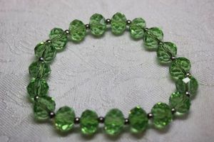 lot 120 image: Vibrant faceted green glass stretch bracelet with silver finish spacers.