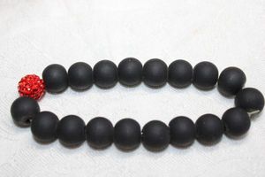 lot 122 image: Matte black glass bead stretch bracelet with red crystal focal bead.