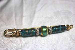 lot 131 image: Art glass gold finish unusual brooch  pin with glass beads in safety pin form. 4.5L