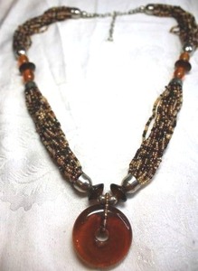 lot 171 image: Multi strand micro glass bead necklace with silver caps and amber color glass donut pendant. 22L with 2 extender
