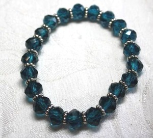 lot 191 image: Faceted teal blue green stretch bracelet with silver finish disc spacers.