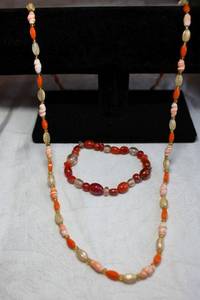 lot 205 image: Nautical orange and cream color glass bead necklace with sea shell shaped glass beads, 30L. Includes an orange and red stretch bracelet