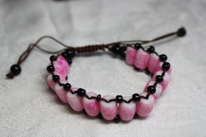 lot 208 image: Marbled pink cased glass barrel bead bracelet with pull tight cords