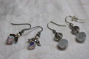 lot 211 image: (2) Faceted glass ear wire earrings, One is a figural angel with pearl head.