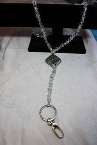 lot 223 image: Faceted clear AB glass necklace with oversize pinch clasp. Can be worn long as a Y-necklace or doubled with clasp. 28L. Overall 42L Can also be worn as lanyard