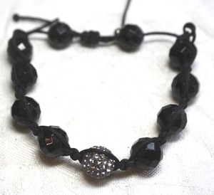 lot 229 image: Woven (larger size than most) faceted black glass bead bracelet with rhinestone focal bead and pull tight closure.